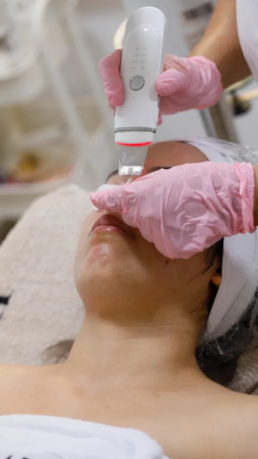 Le travail avec l’appareil — Un appareil est utilisé sur le visage.